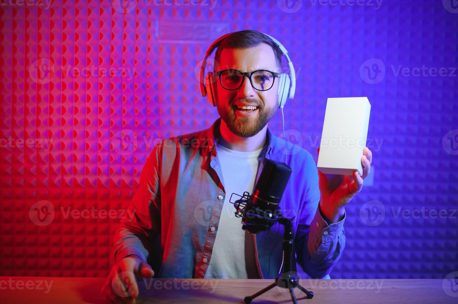 Beau Jeune homme faire des gestes tandis que déballage colis, excité, serre les poings dans triomphe. joyeux Masculin vlogger. concept de gens et social réseaux. photo