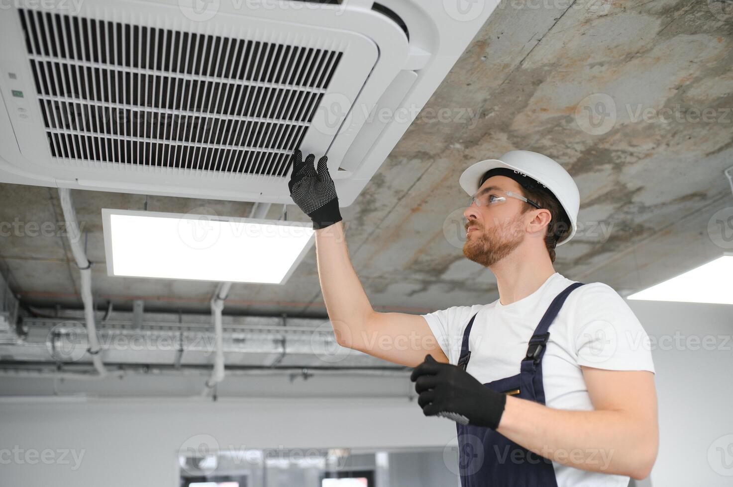 Beau Jeune homme électricien installation air conditionnement. photo