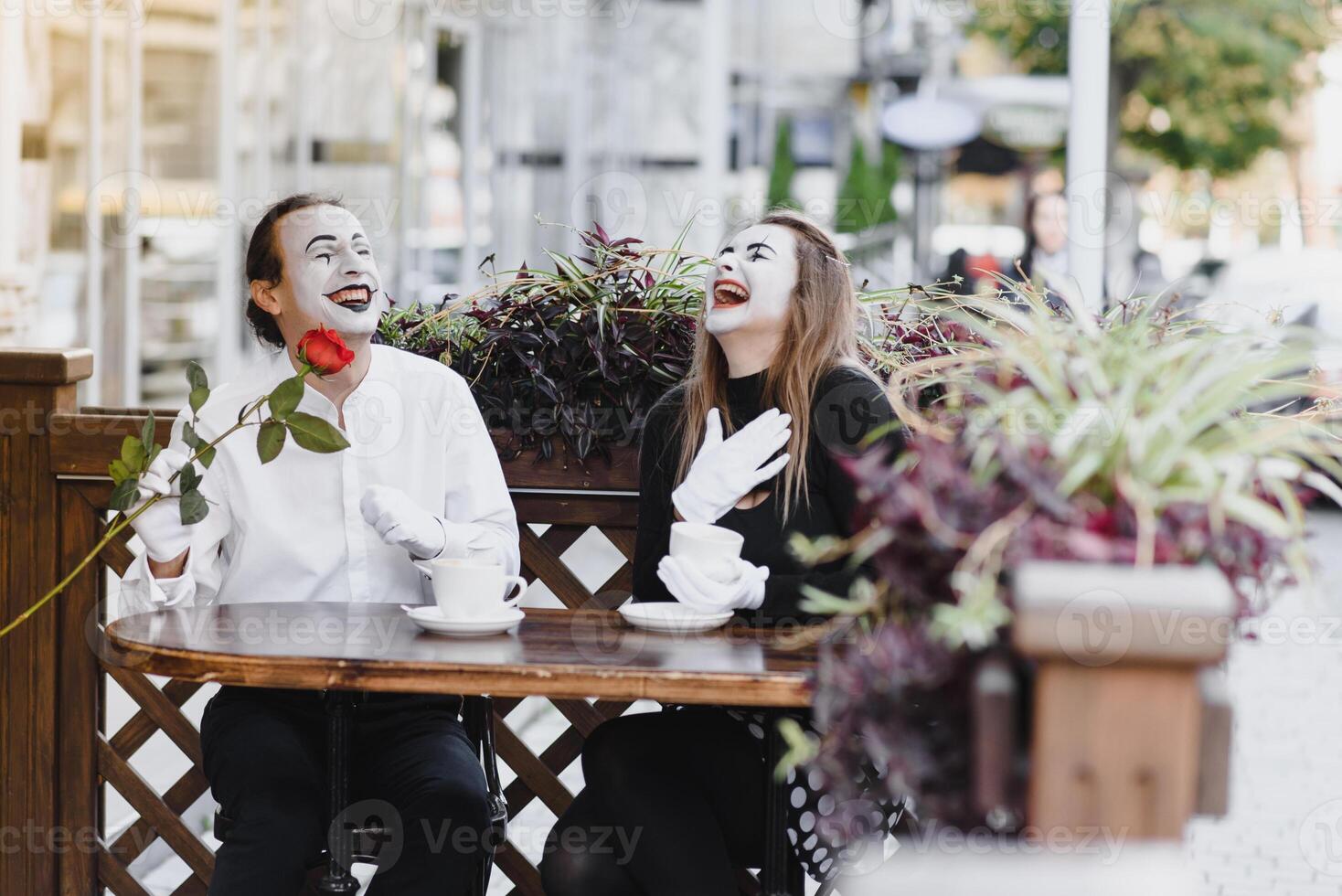 mimes dans de face de Paris café agissant comme en buvant thé ou café. photo