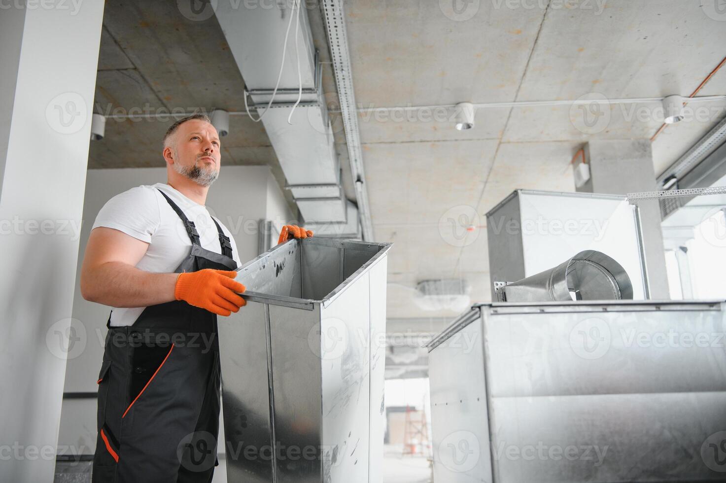 HVAC prestations de service - ouvrier installer canalisé tuyau système pour ventilation et air conditionnement dans bureau. photo