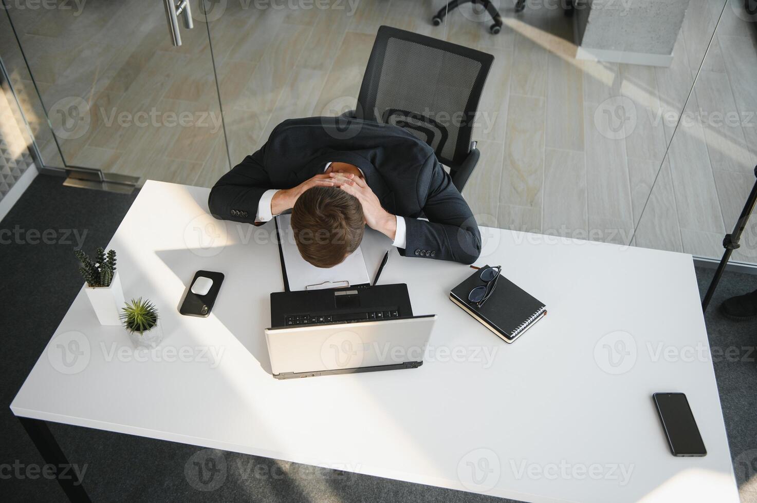 portrait de stressé en dehors et inquiet gênant surmené homme d'affaire entrepreneur à la recherche les documents rapport dans moderne brillant Bureau travail en dessous de pression et serré date limite photo