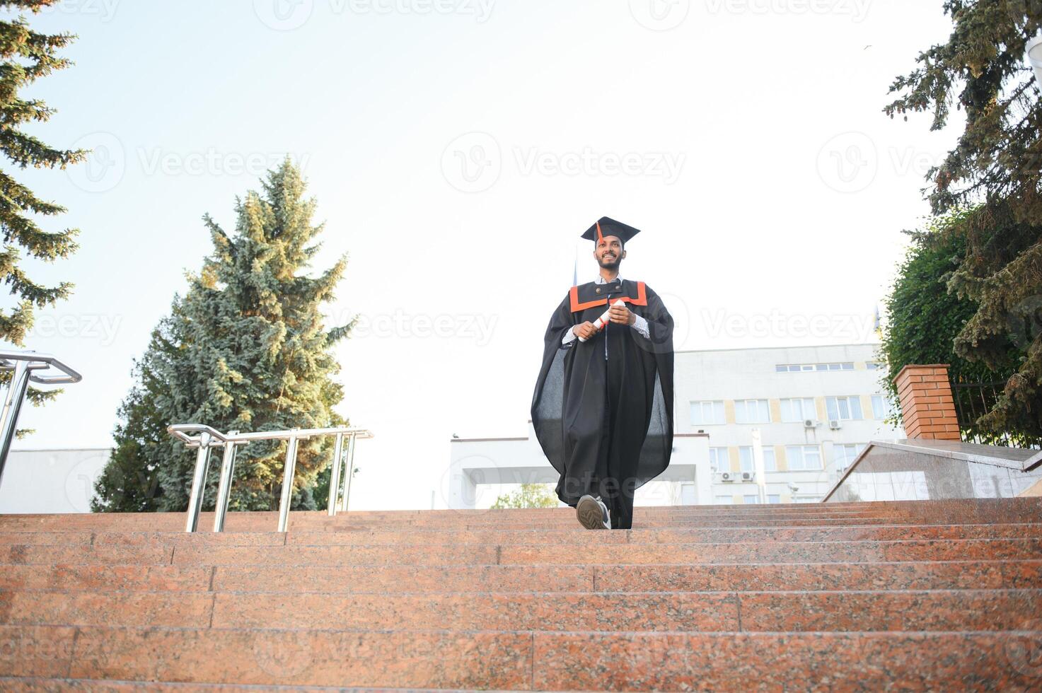 Beau Indien diplômé dans l'obtention du diplôme lueur avec diplôme. photo