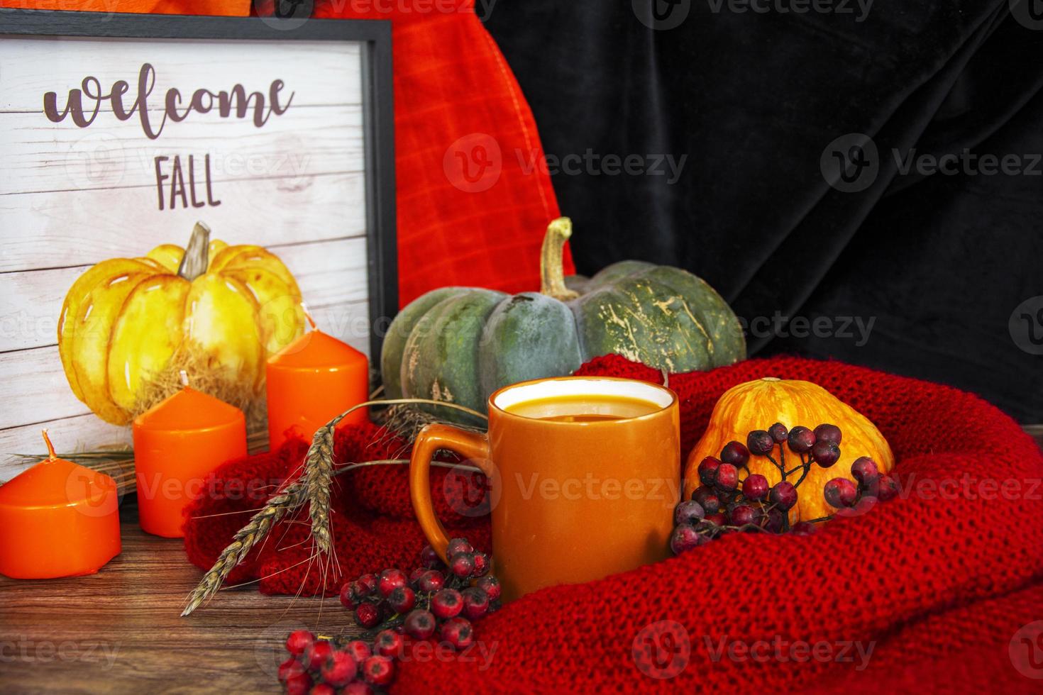 Halloween nature morte. citrouilles, bougies oranges et une tasse de jus de citrouille sur une serviette. photo