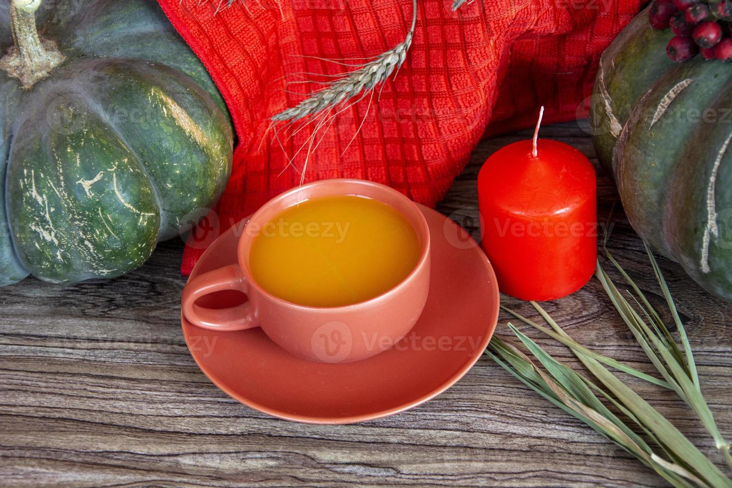 nature morte d'automne avec des citrouilles. citrouilles, bougies et une tasse sur une table en bois. photo