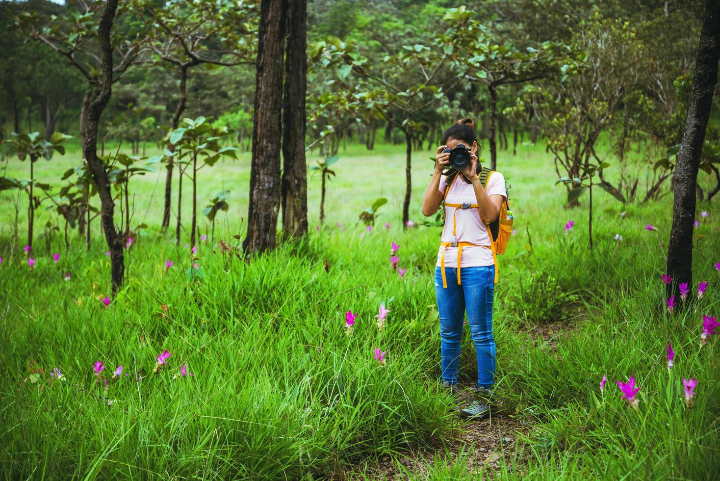 femme asiatique voyage nature. voyage se détendre. champ de fleurs de sessilis de concombre de photographie. photo