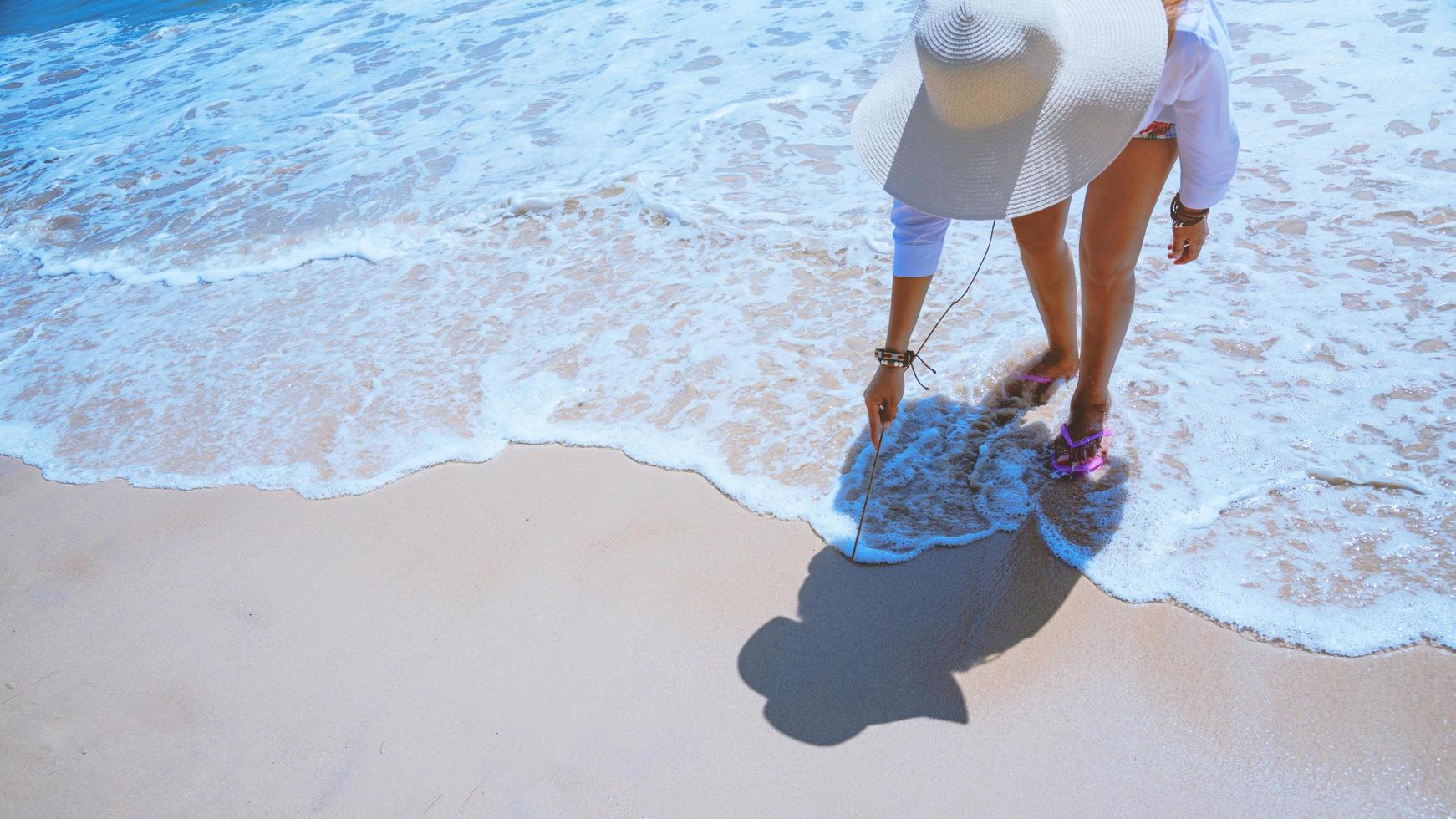 les femmes asiatiques voyagent dans la nature. voyage se détendre. jouer à l'eau de mer sur la plage. en été. Thaïlande photo