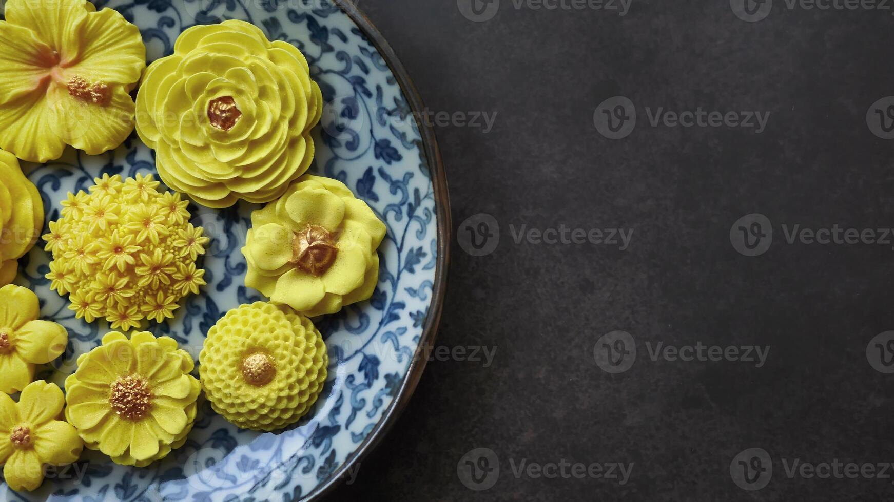 thaïlandais dessert dans divers fleur en forme de, chaud Couleur Ton, Jaune mangue saveur dans antique modèle plaque, sam la poêle née traditionnel thaïlandais artisanat casse-croûte dans foncé Contexte photo