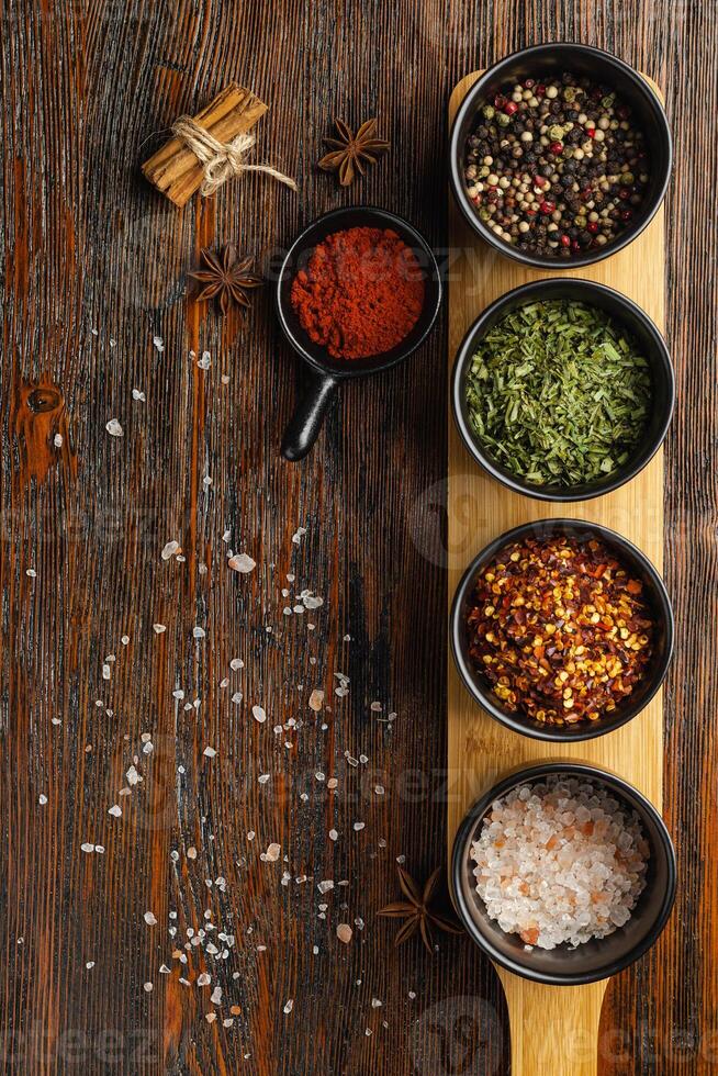 Diverses herbes et épices colorées pour la cuisson sur fond sombre photo