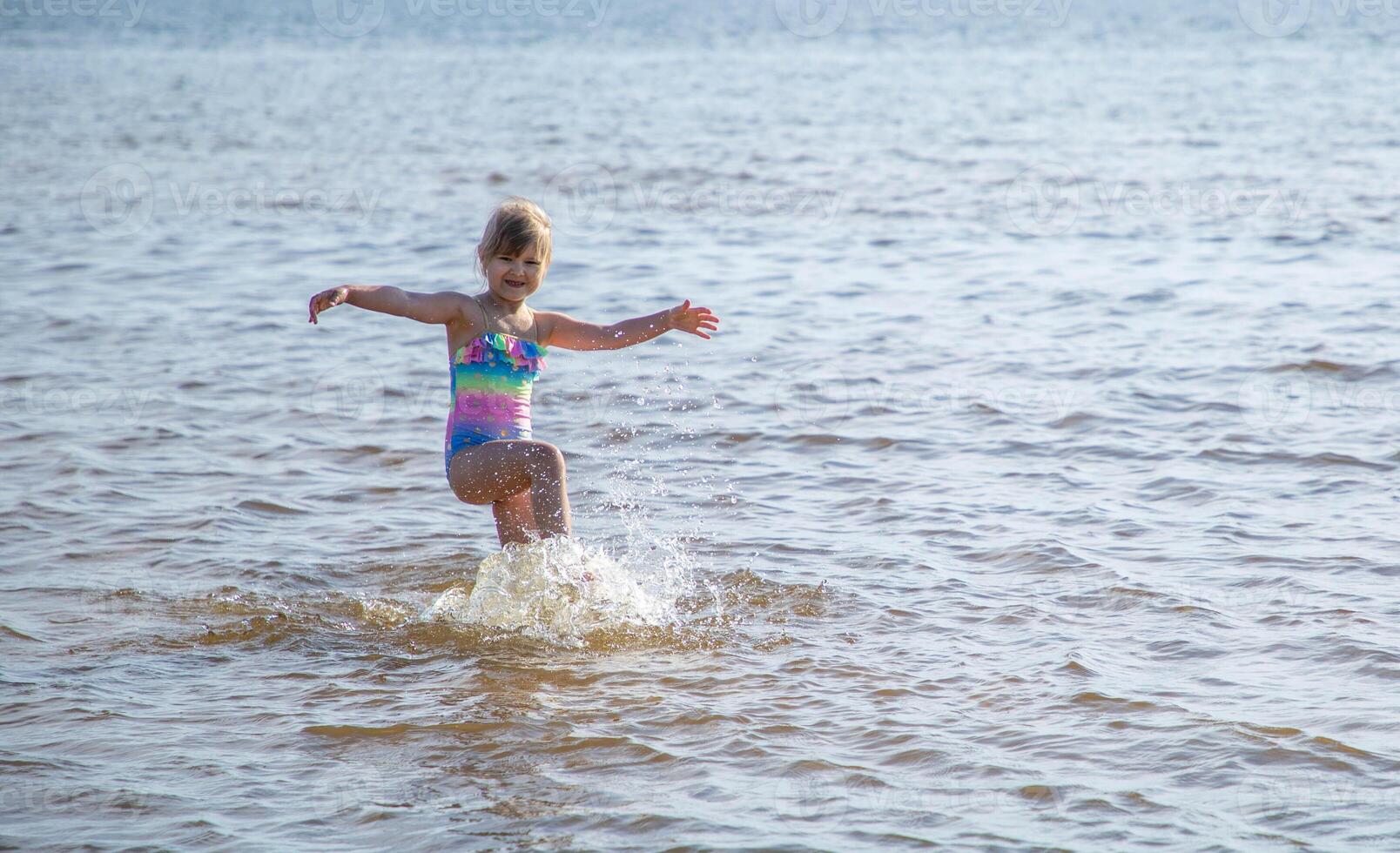 Jeune content enfant fille de européen apparence âge de 6 ayant amusement dans l'eau sur le plage et éclaboussures,tropical été vocations,vacances.a enfant jouit le mer.famille vacances concept.copy espace. photo