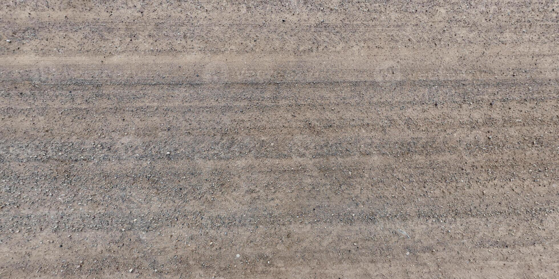 vue d'en haut sur la texture de la route de gravier avec traces de pneus de voiture photo
