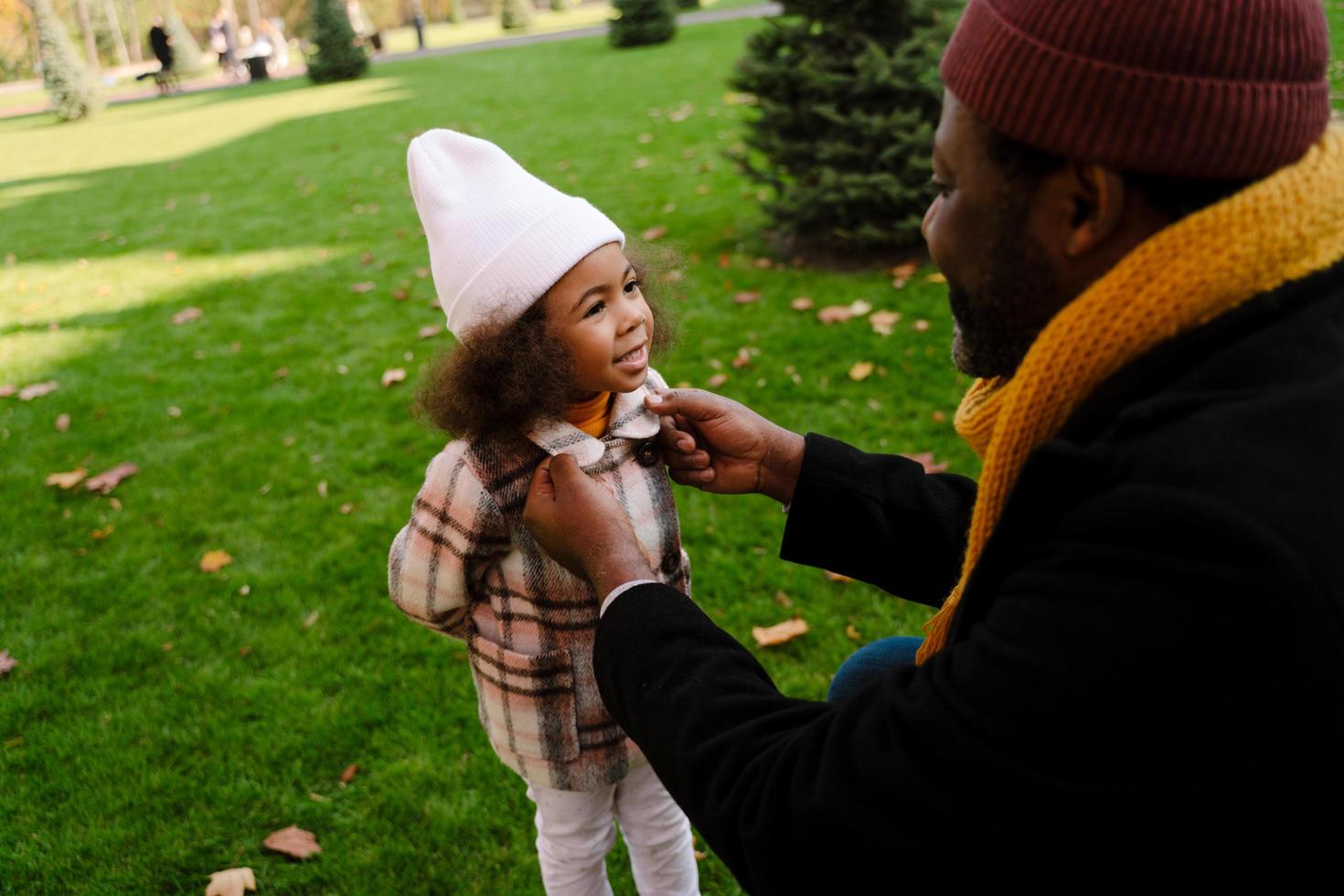 grand-père noir parlant avec sa petite-fille pendant la marche à l'extérieur photo