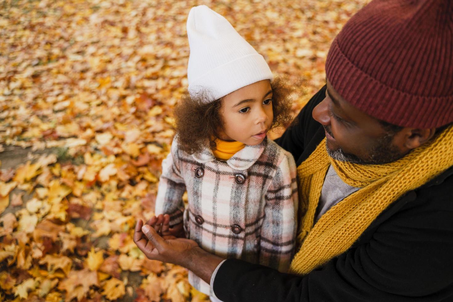 grand-père et petite-fille noirs s'amusant en jouant ensemble dans un parc d'automne photo