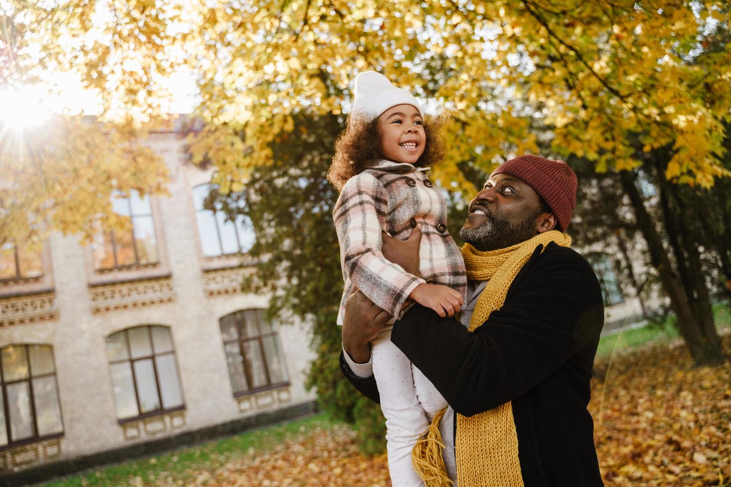 fille noire s'amusant et assise sur le cou de son grand-père dans le parc d'automne photo