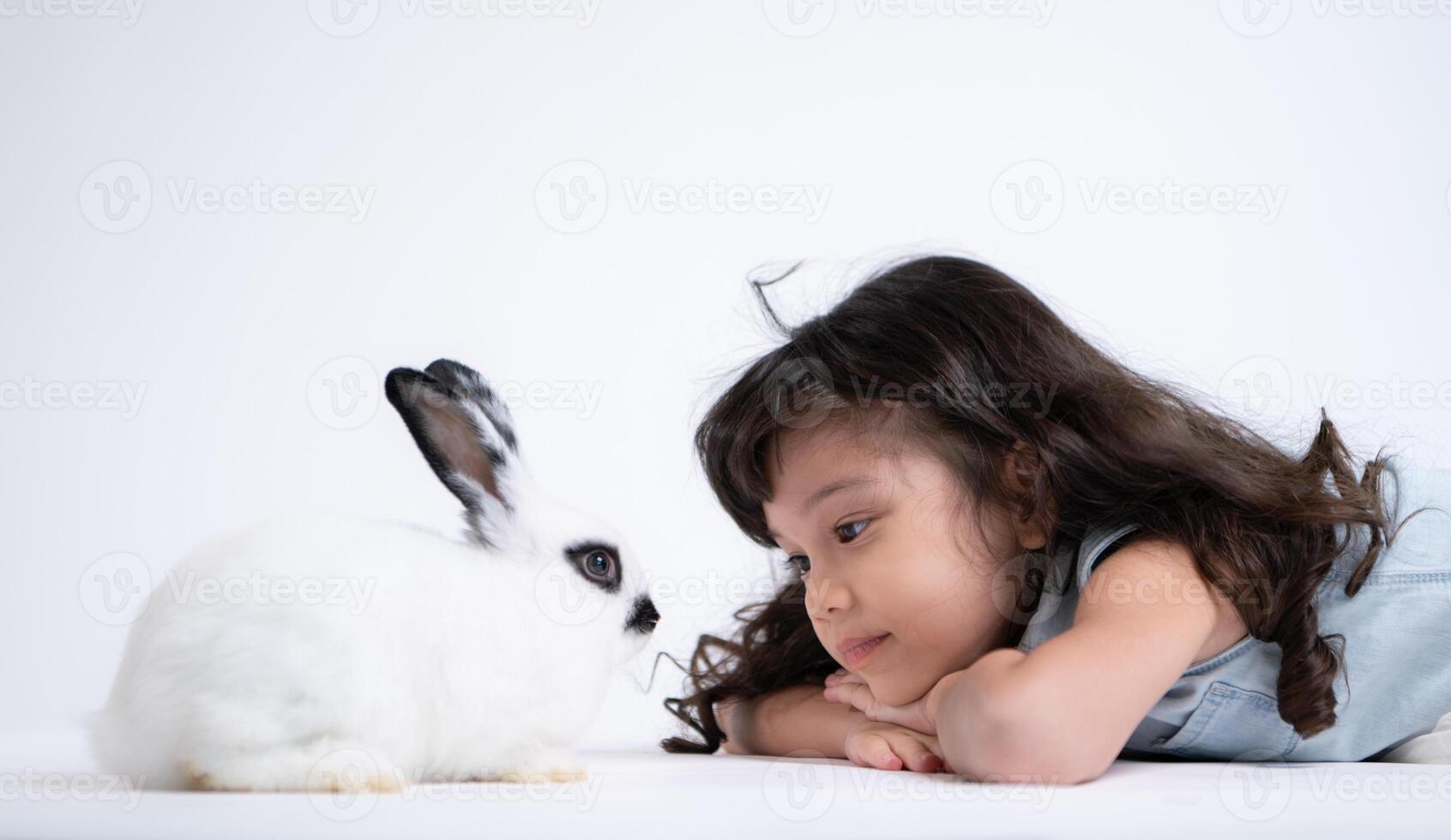 une peu fille baisers sa bien-aimée duveteux lapin, le beauté de relation amicale entre humains et animaux photo