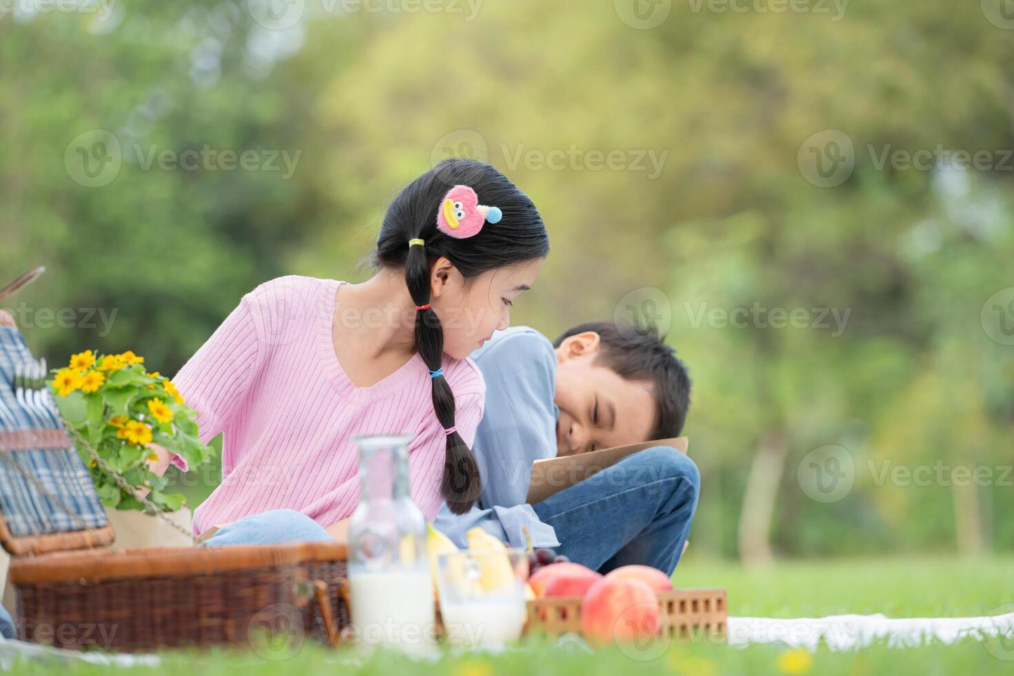 content famille profiter une pique-nique dans le parc, les enfants séance retour à retour et en train de lire livres. photo