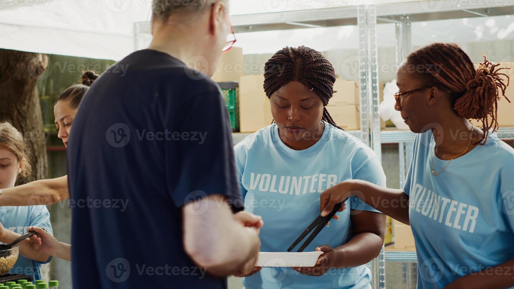 concentrer sur africain américain femmes à nourriture conduire portion gratuit chaud repas à le pauvres caucasien sans abri homme. à local centre, groupe de bénévoles alimentation et soutien le faim et Moins chanceux personnes. photo