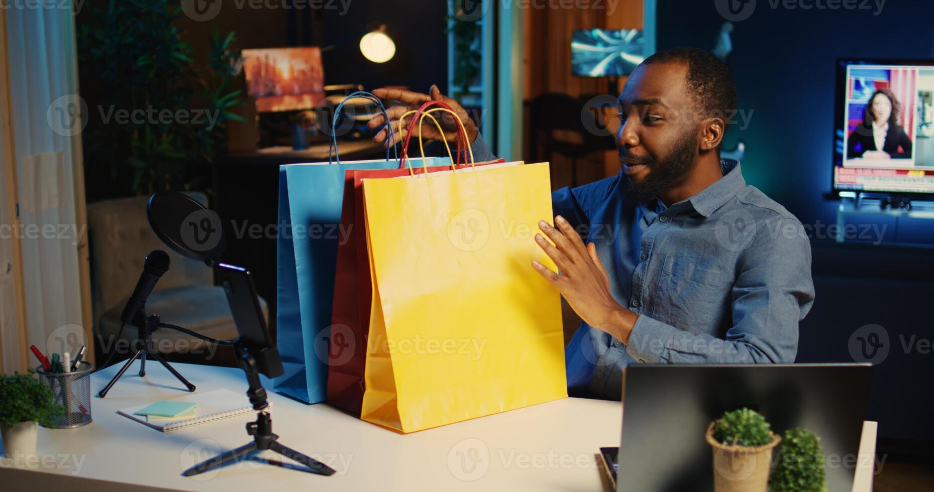 contenu créateur en portant achats Sacs, tournage transporter vidéo dans vaguement allumé studio. l'Internet étoile déballage Vêtements articles il acheté, révision mode magasins marchandise, en utilisant professionnel caméra photo