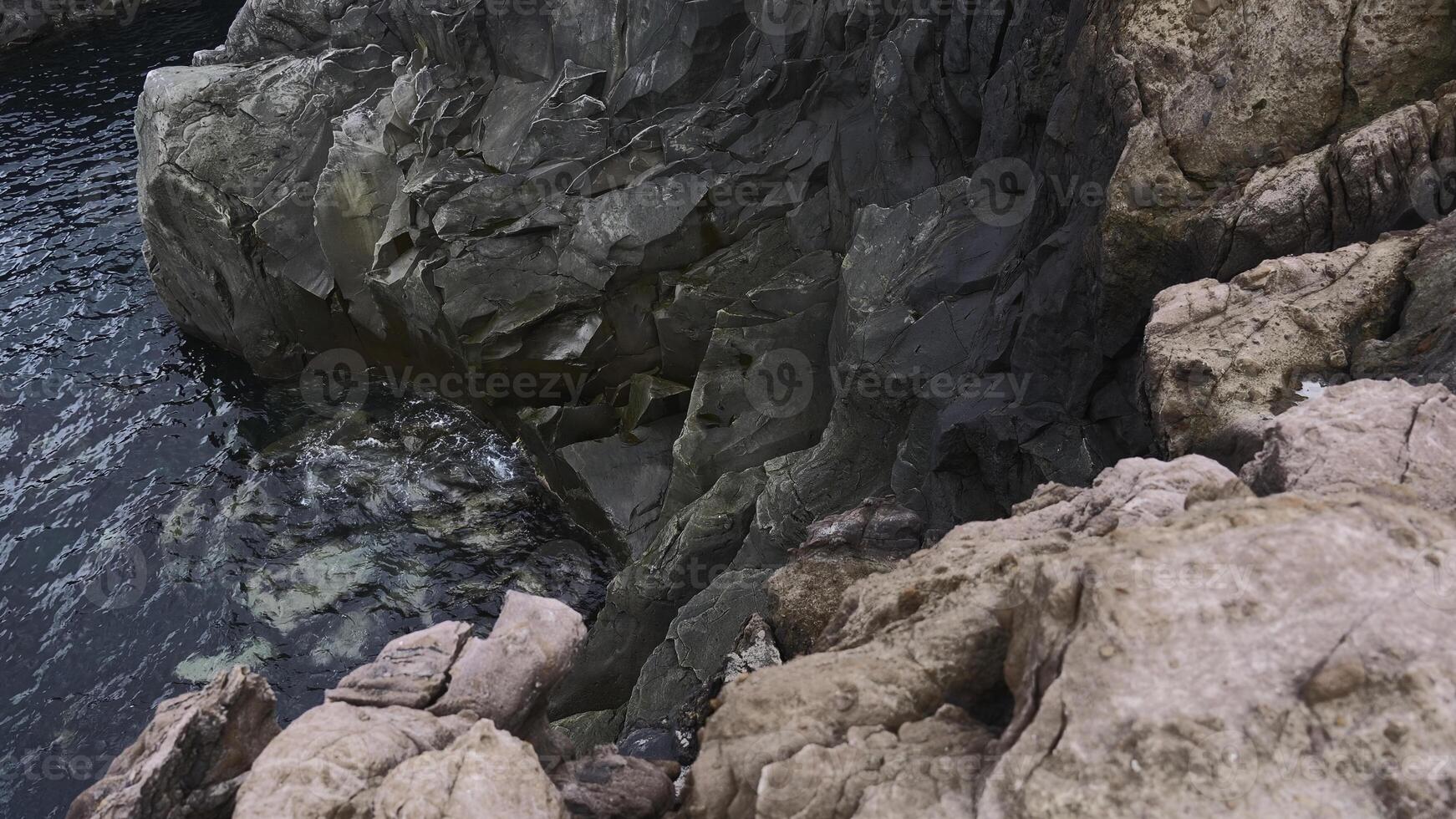 vue de dangereux pierre falaises près mer l'eau. agrafe. sur bord de vertigineux falaises par mer l'eau. magnifique et dangereux tranchant rochers avec mer l'eau photo