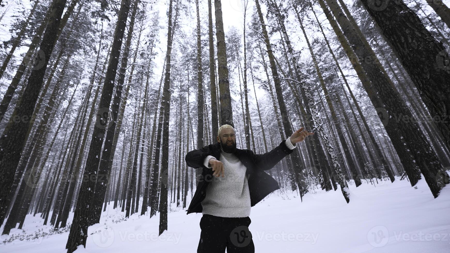 homme dansant dans hiver forêt. médias. élégant homme tournage vidéo agrafe dans hiver forêt. tournage élégant homme dans hiver forêt photo