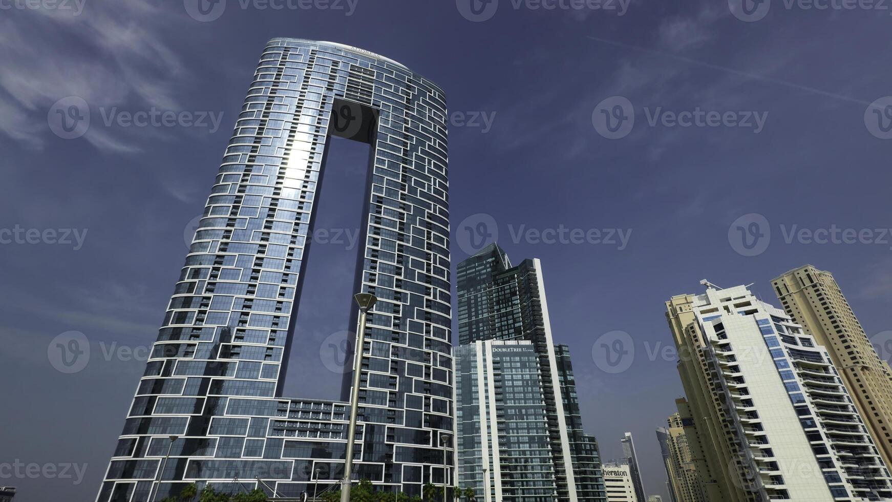 faible angle vue de le adresse plage station balnéaire, Dubai, uni arabe émirats. action. magnifique gratte-ciel avec une rectangulaire en forme de trou dans bâtiment. photo