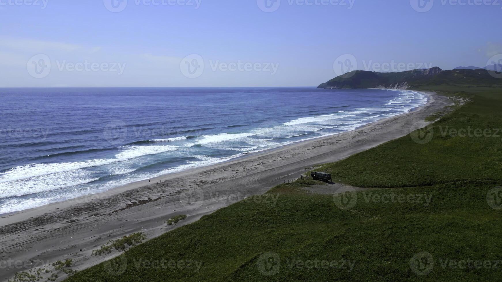 panoramique aérien coup de une ensoleillé côtier paysage dans Espagne. agrafe. vert Prairie hauts plateaux et mer rive avec touristes près le autobus. photo