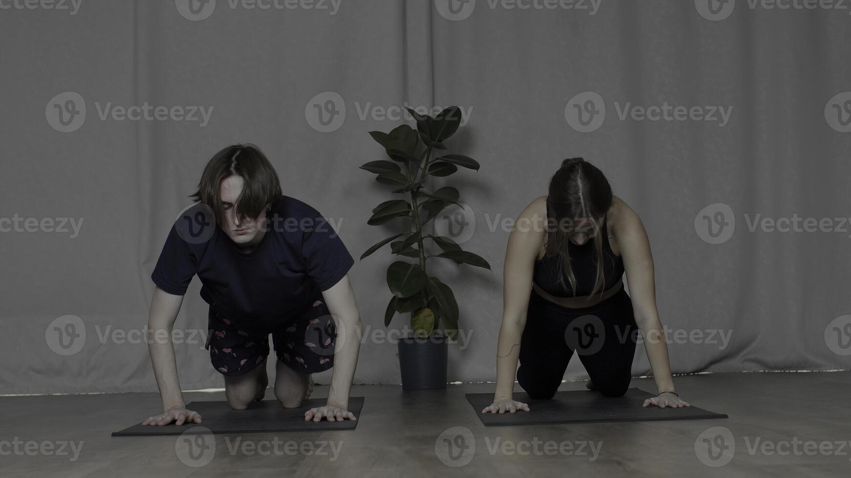 Jeune homme et femme Faire yoga sur tapis. médias. concept de sport et corps se soucier. photo