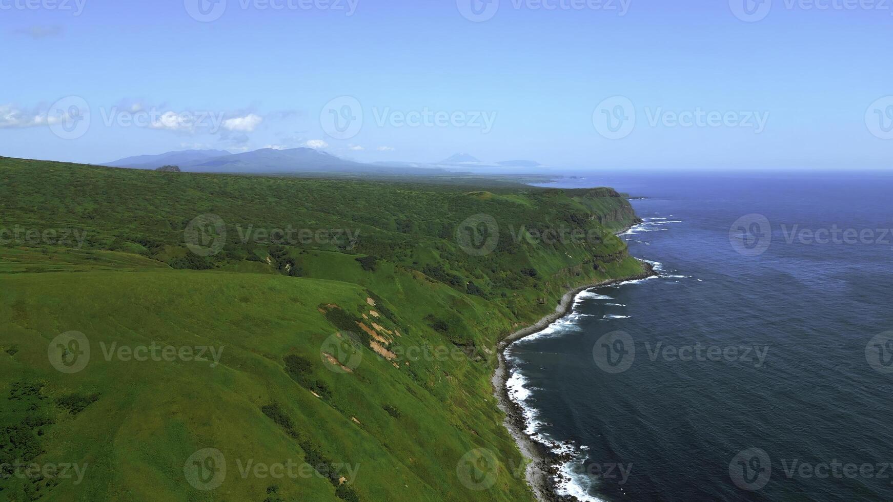 sauvage nature, vert montagnes avec raide vert pistes de premier plan à le mer. agrafe. aérien de mousse de bleu vagues Pause dans volcanique rochers. photo