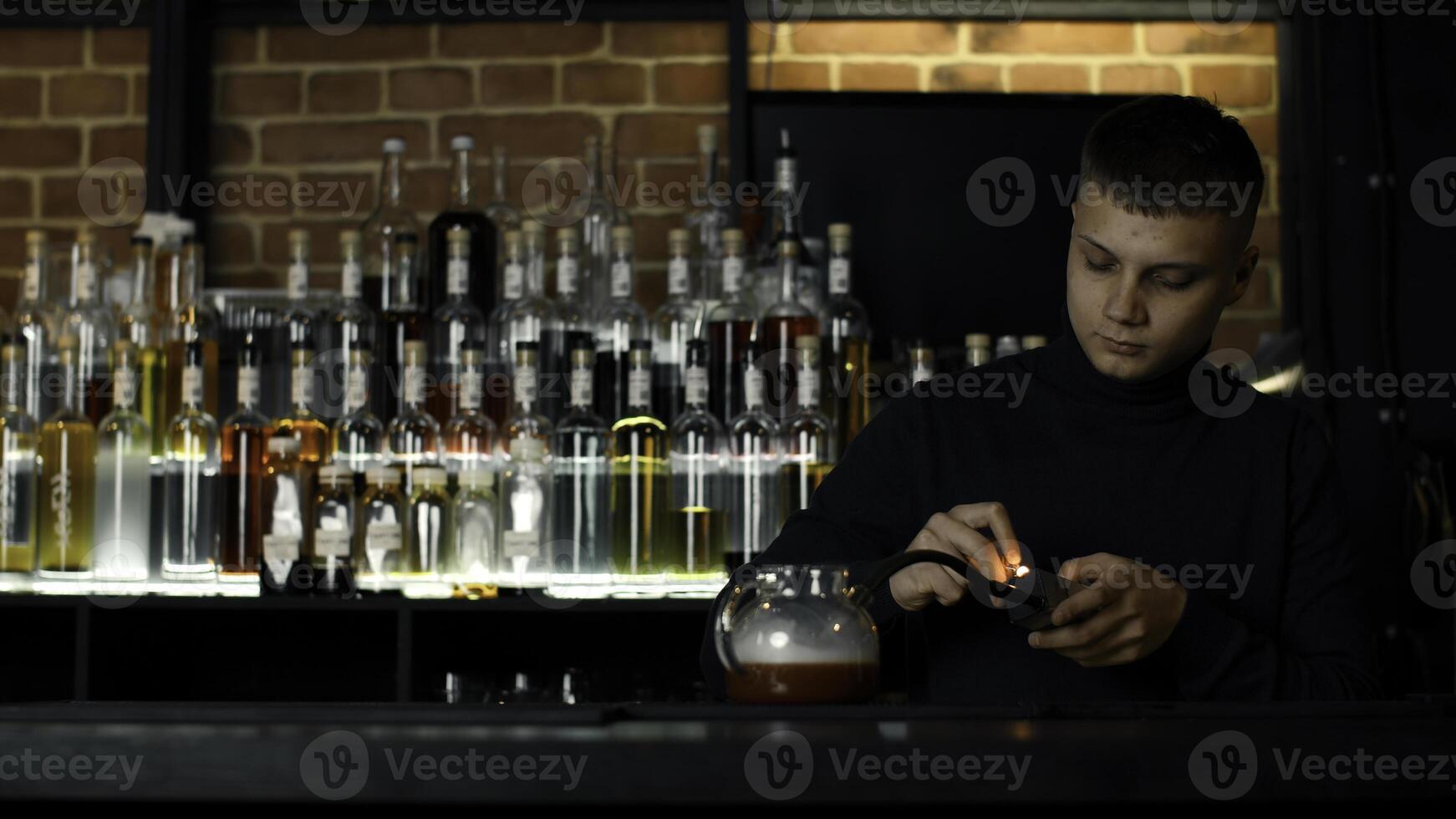 barman fabrication inhabituel cocktail dans une thé pot à le bar. médias. ajouter fumée dans le chaud cocktail. photo