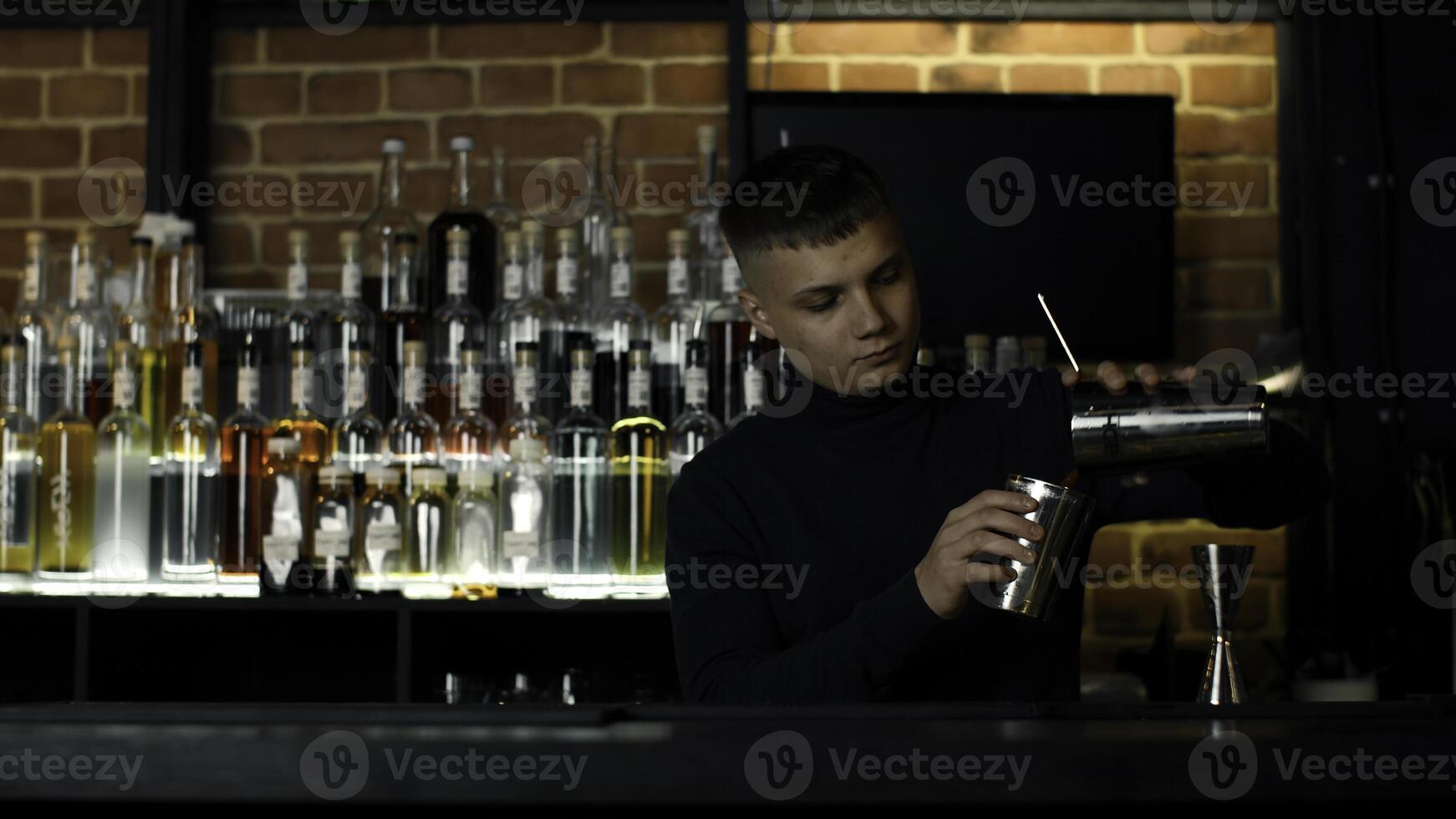 le processus de en train de préparer un alcoolique cocktail à le bar. médias. Jeune Masculin barman à travail. photo