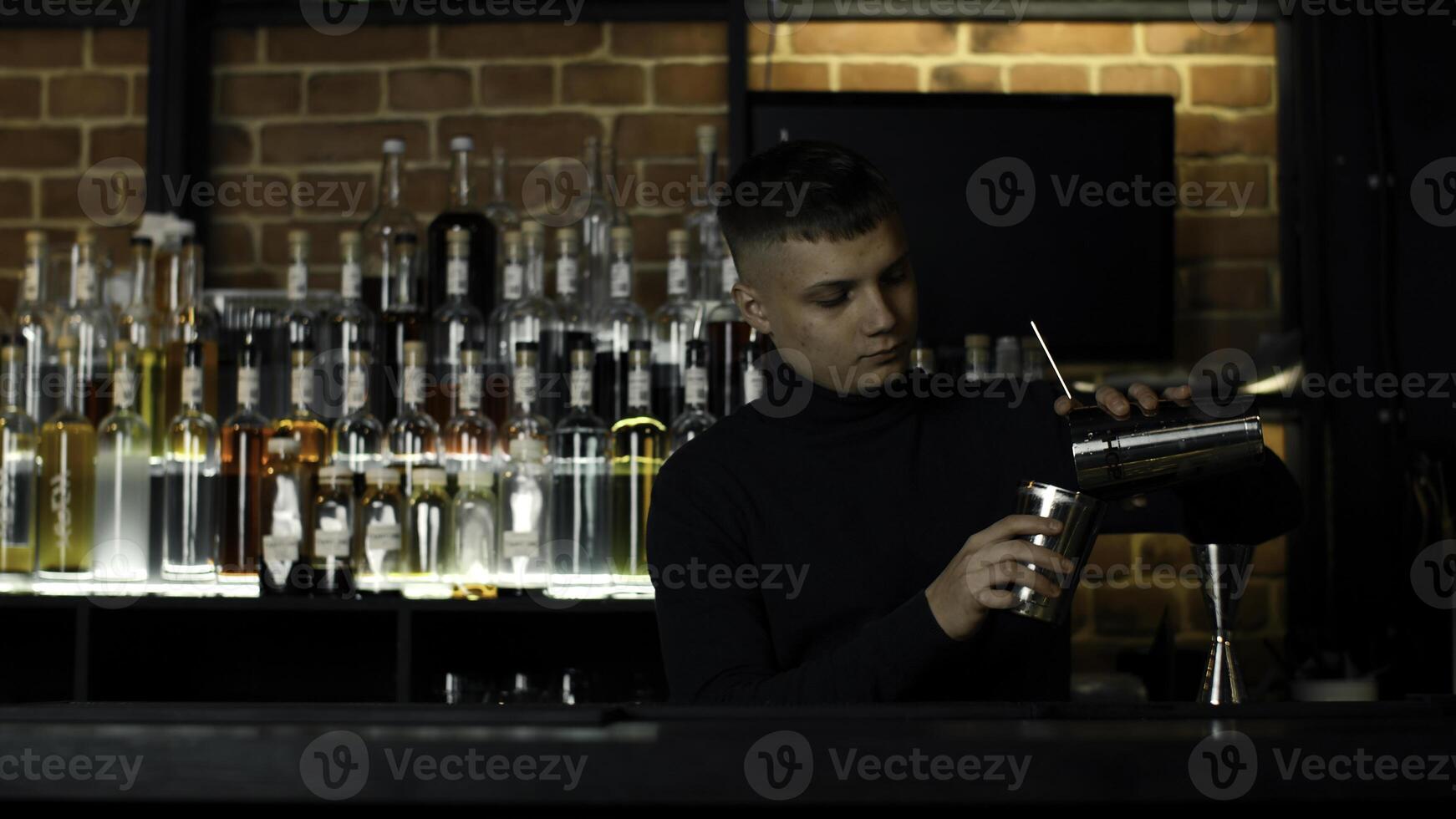 Jeune Masculin barman en utilisant Mixeur pour le de l'alcool boisson préparation. action. concept de fête à nuit club. photo