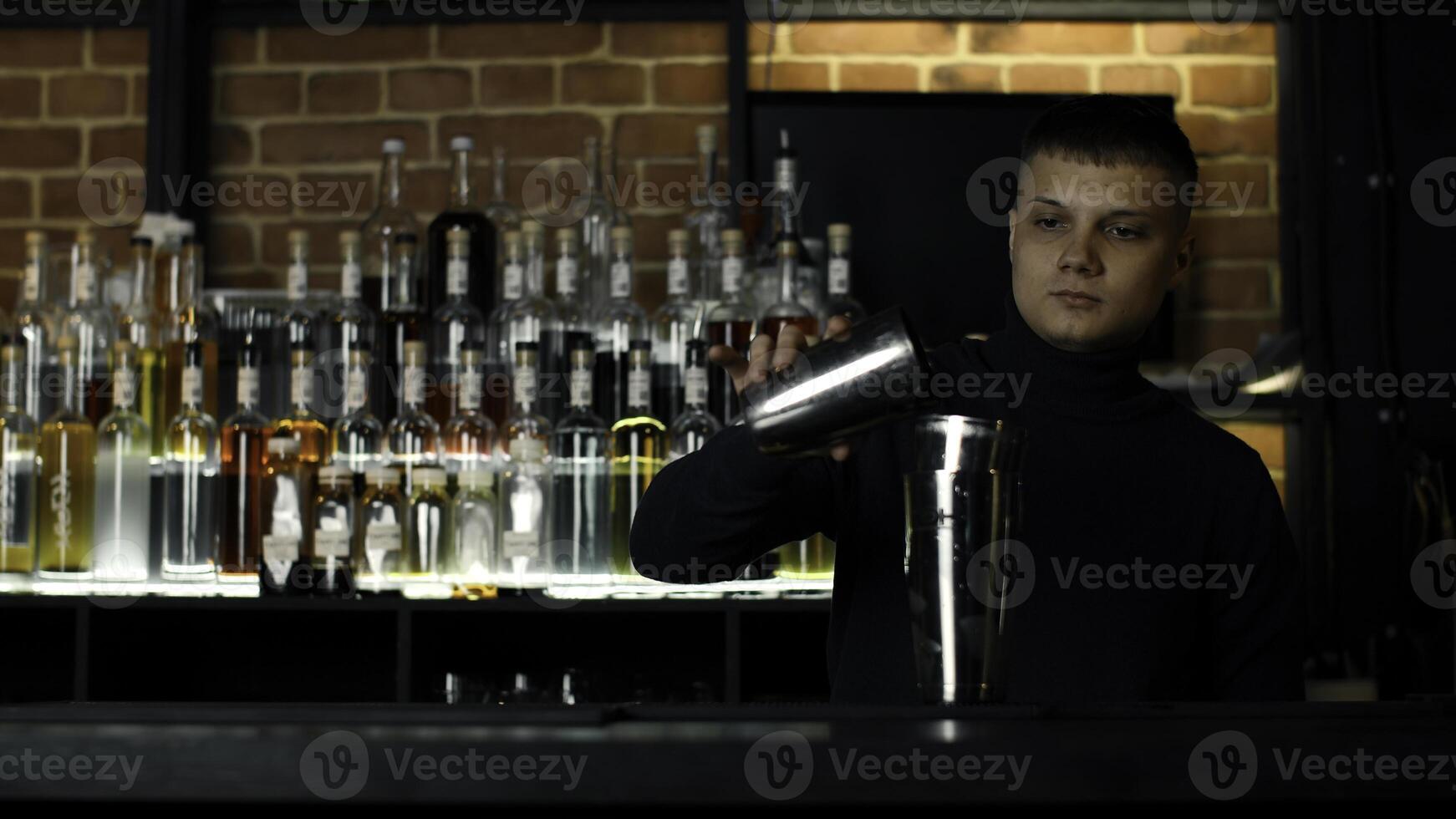 Jeune Masculin barman en utilisant Mixeur pour le de l'alcool boisson préparation. action. concept de fête à nuit club. photo