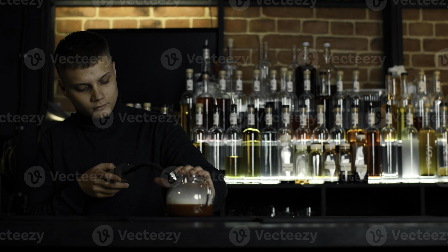barman fabrication inhabituel cocktail dans une thé pot à le bar. médias. ajouter fumée dans le chaud cocktail. photo