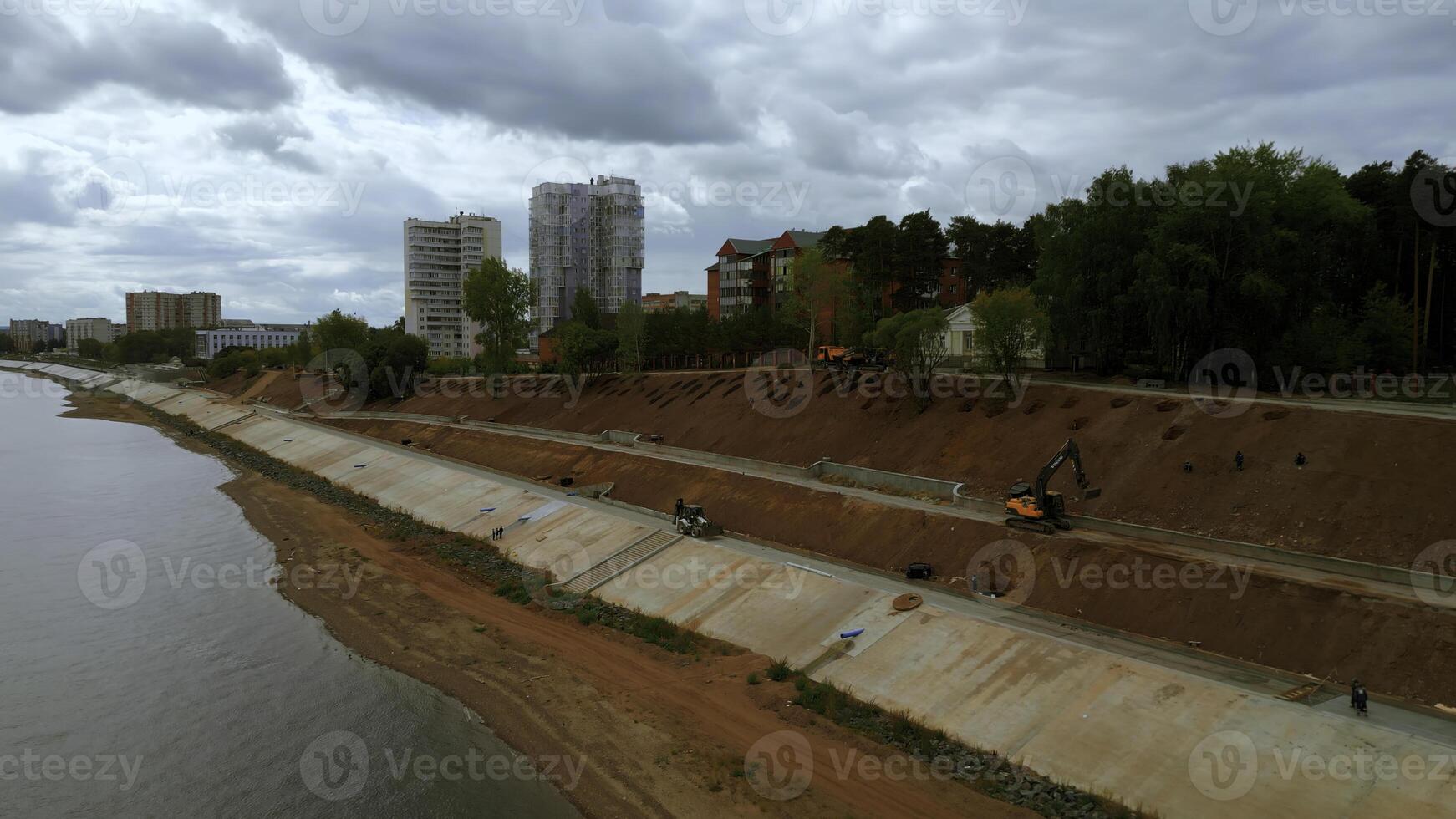 construction et renforcement de une Nouveau sécurité digue le long de le rivière. agrafe. aérien vue ov le amélioration ville zone. photo