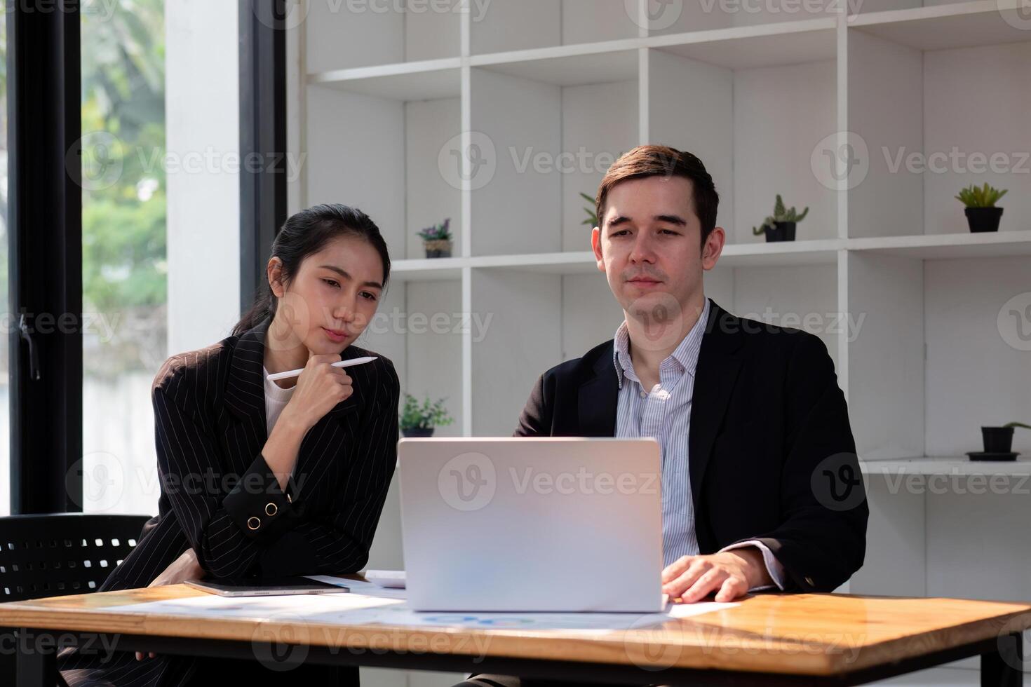 équipe affaires de diverse partenaire affaires femme discuter projet sur portable séance à table dans bureau. deux collègue de professionnel affaires gens travail ensemble photo