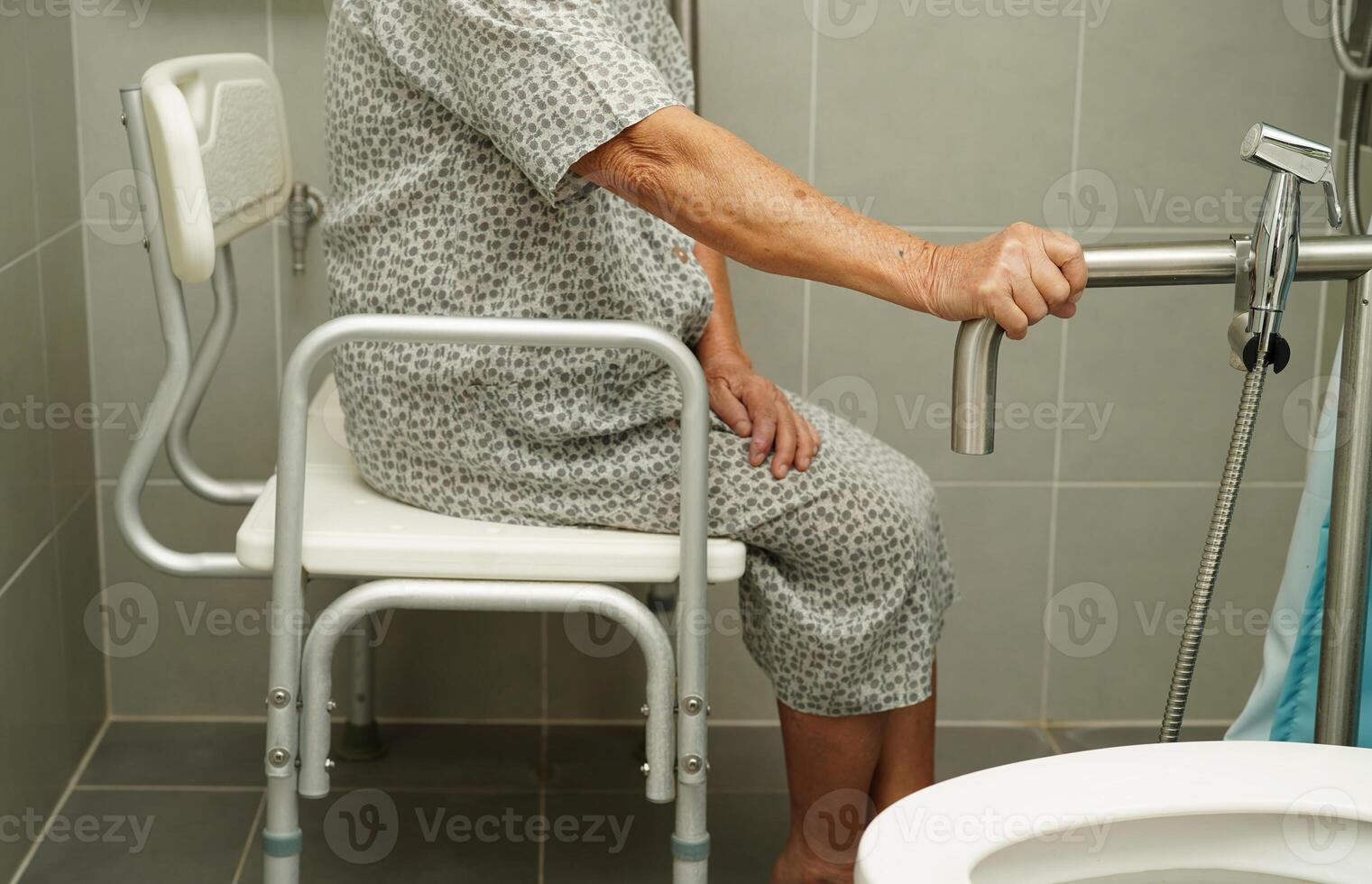 une vieille femme asiatique âgée utilise un rail de support de toilette dans la salle de bain, une barre d'appui de sécurité pour main courante, la sécurité dans l'hôpital de soins infirmiers. photo