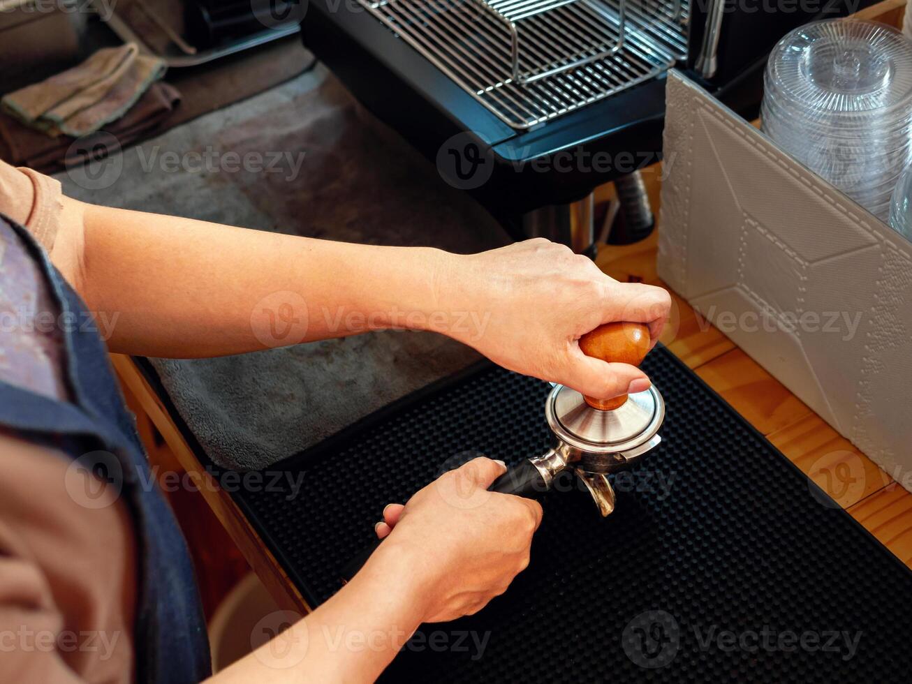 Haut vue de barista en portant porte-filtre et café altérer fabrication un Expresso café dans café magasin photo