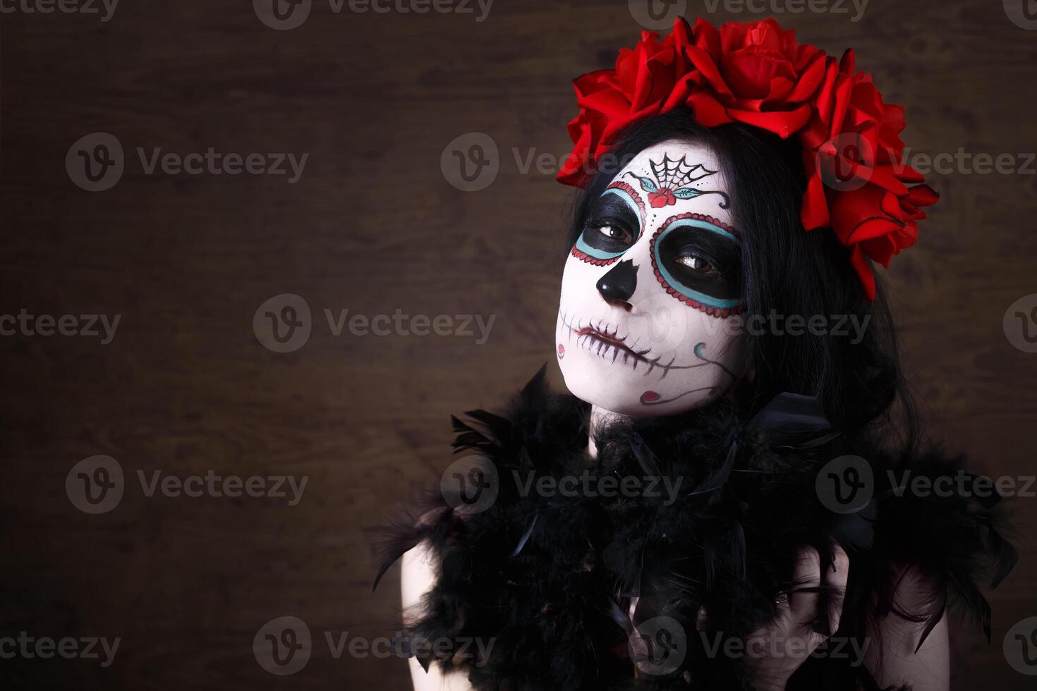 journée de le mort. Halloween. Jeune femme dans journée de le mort masque crâne visage art et Rose. foncé Contexte. photo