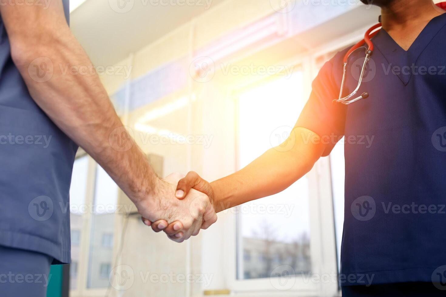 deux Jeune médecins tremblement mains à chaque autre. multiracial équipe de Jeune médecins. photo