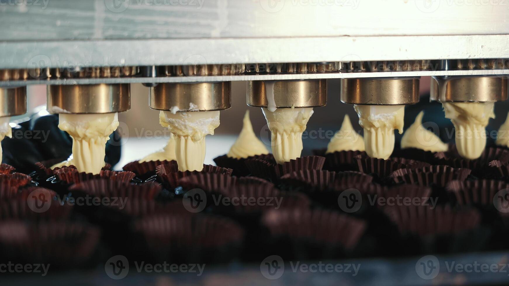 automatique remplissage de petit gâteau moules avec pâte. le concept de fabrication confiserie, biscuits, des friandises, petits gâteaux. proche en haut photo