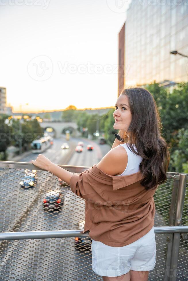 attrayant Jeune femme profiter sa gratuit temps à le coucher du soleil Extérieur. content fille portrait à été. liberté mode de vie été concept. Soleil lueur sur Contexte. haute qualité photo