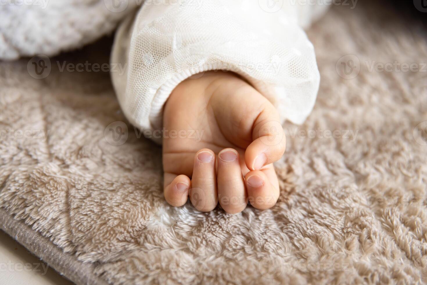 une la gauche main de en train de dormir asiatique bébé sur le tapis photo