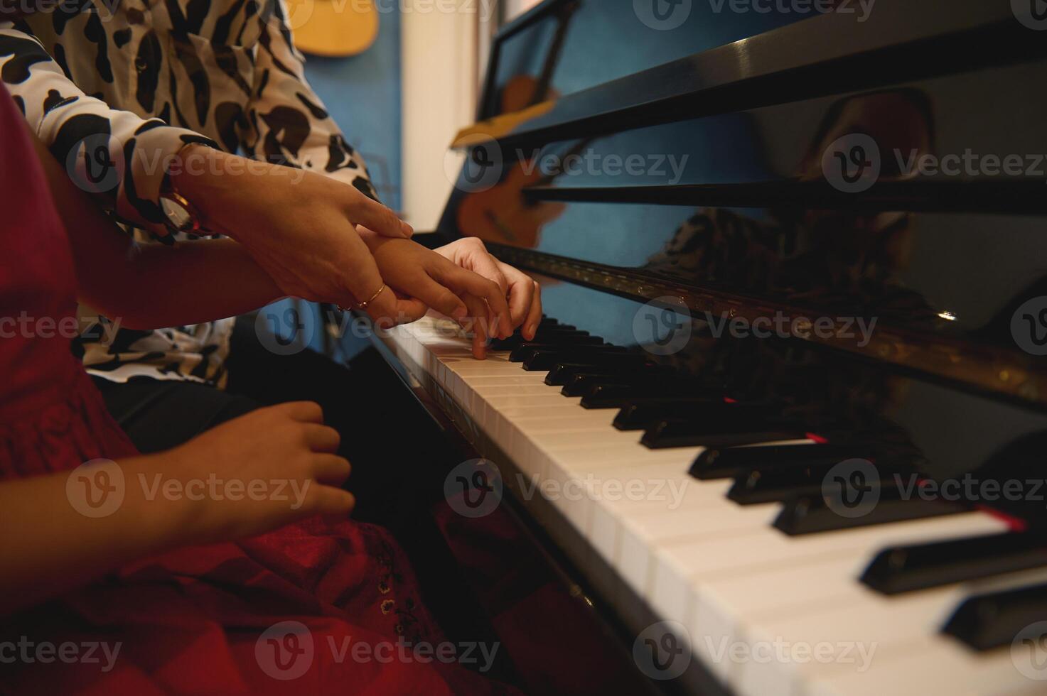 côté vue de une la musique professeur, musicien pianiste en portant le mains de une enfant fille, enseignement piano, montrant le correct doigt position. loisirs et loisirs. des gamins éducation, artistique compétences développement photo