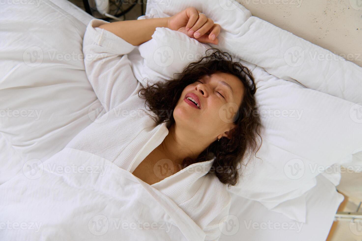 fermer Jeune femme ronflement tandis que en train de dormir dans sa lit. ronflement problèmes. santé se soucier concept photo