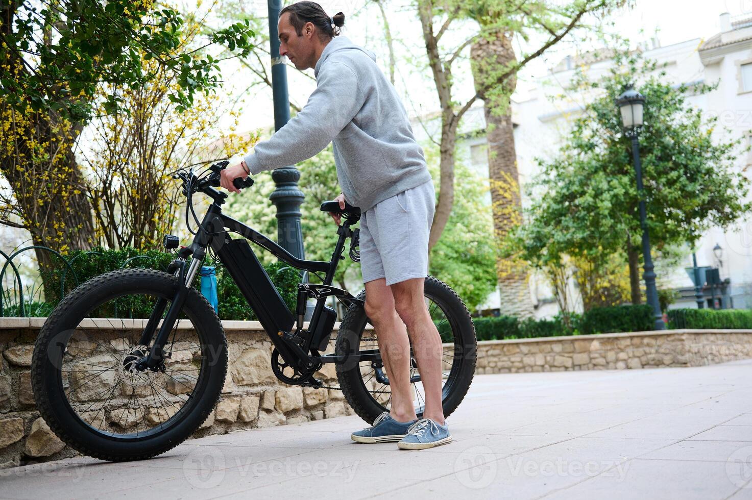 Jeune homme location équitation vélos électriques dans le ville. électrique bicyclette vélo comme confortable écologique mode de Urbain transport photo