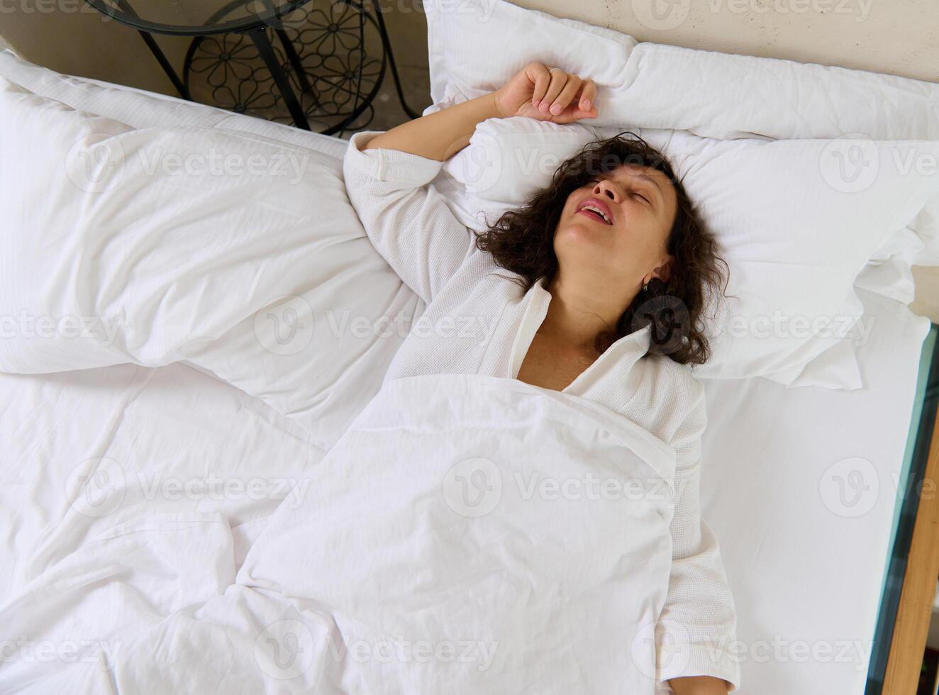 vue de au dessus de une Jeune femme ronflement tandis que en train de dormir dans sa lit photo