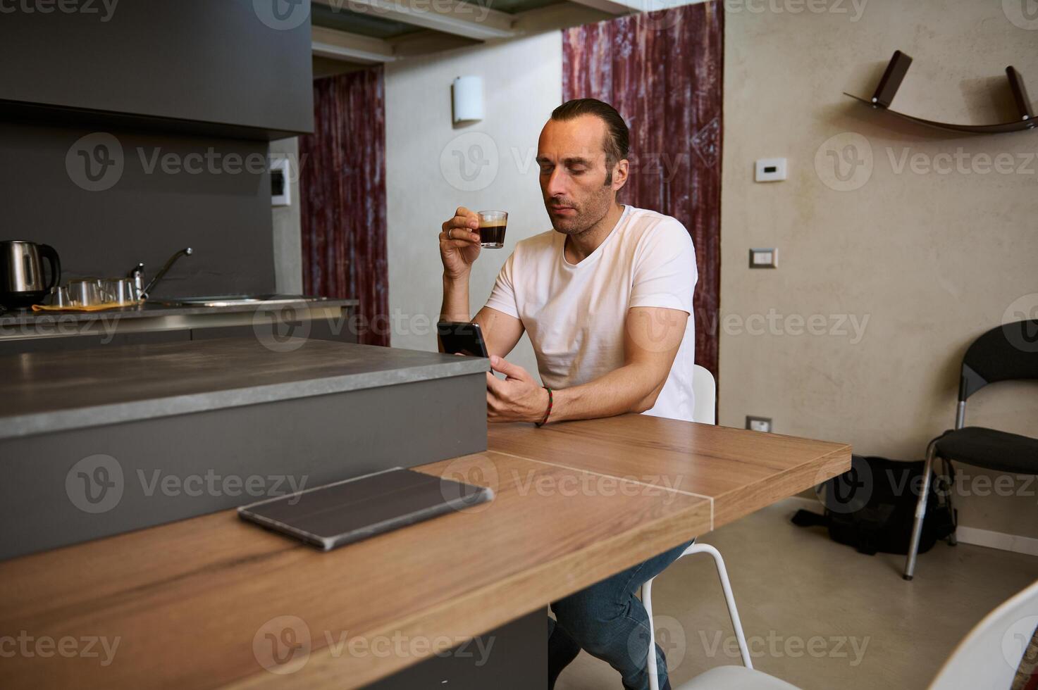 portrait de détendu Jeune affaires homme pigiste prise le sien Matin café, en train de lire nouvelles, vérification social médias contenu photo