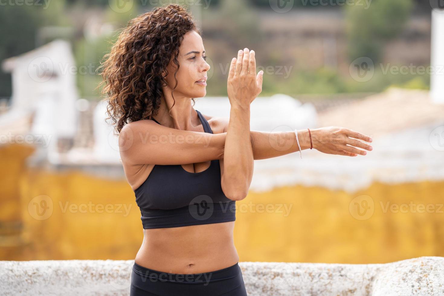 femme d'âge moyen avec un corps de remise en forme travaillant sur la terrasse de sa maison photo