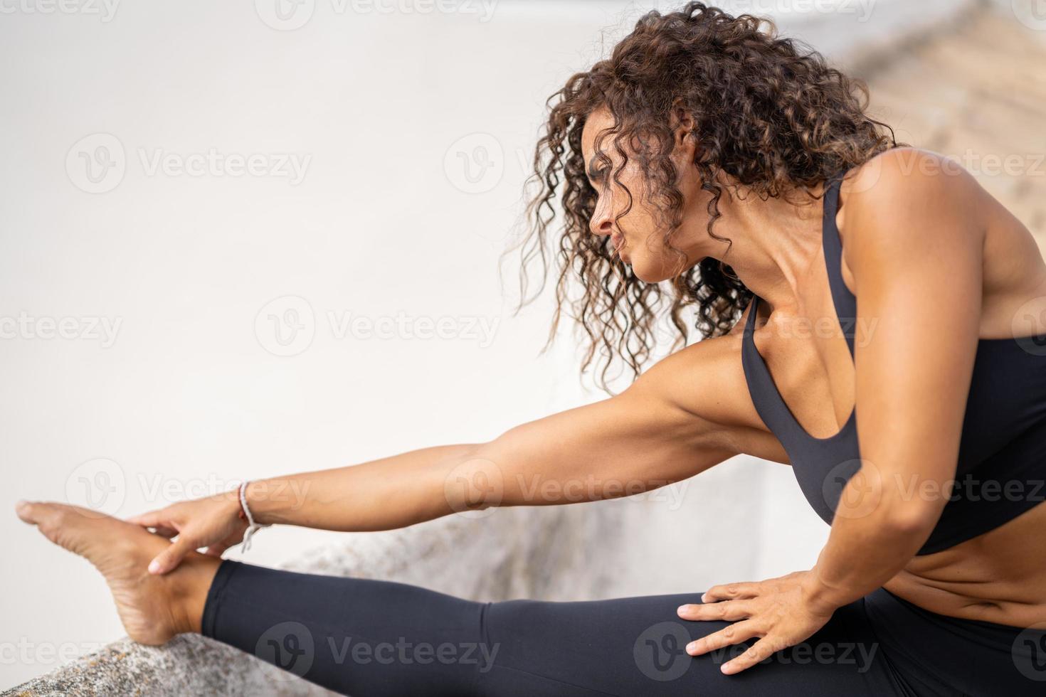 femme d'âge moyen avec un corps de remise en forme travaillant sur la terrasse de sa maison photo