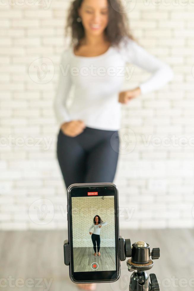 une femme latine a créé sa vidéo de danse avec l'appareil photo d'un smartphone. pour partager la vidéo à l'application de médias sociaux.