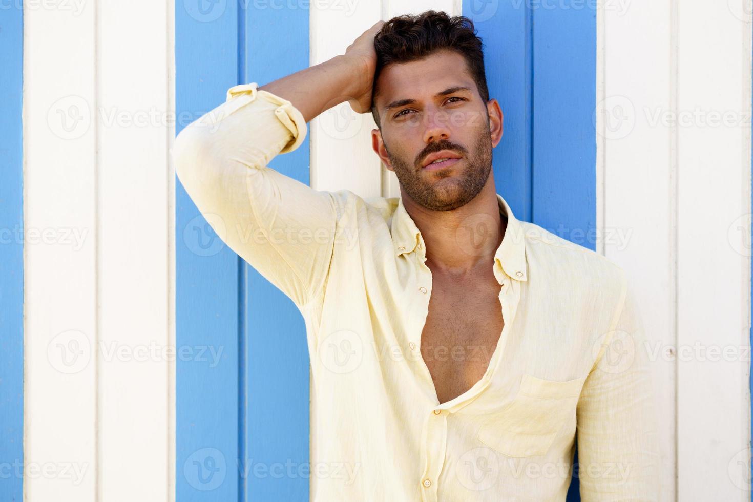 jeune homme, mannequin, posant devant un stand de plage. photo